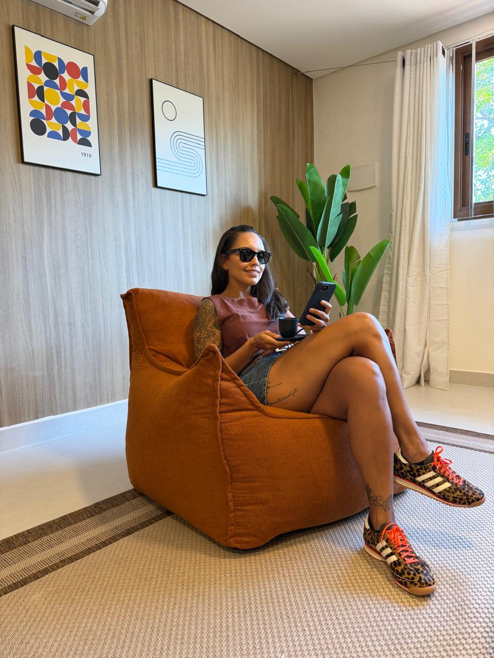 Ambiente de descanso com poltrona em tom terracota